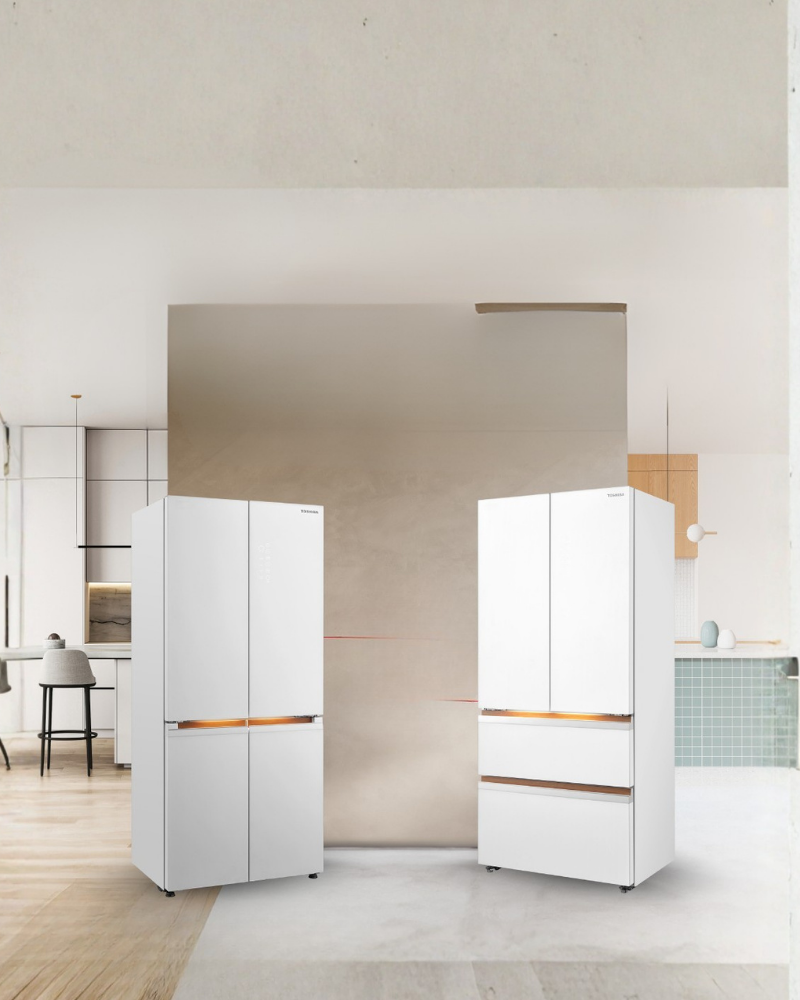Toshiba multi-door white fridges standing in a modern beige kitchen with a tall mirror wall and soft ambient lighting.