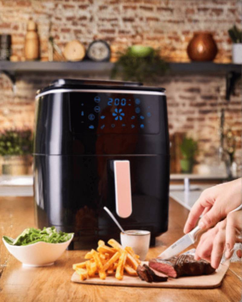 Tefal air fryer with digital display beside fries and steak.