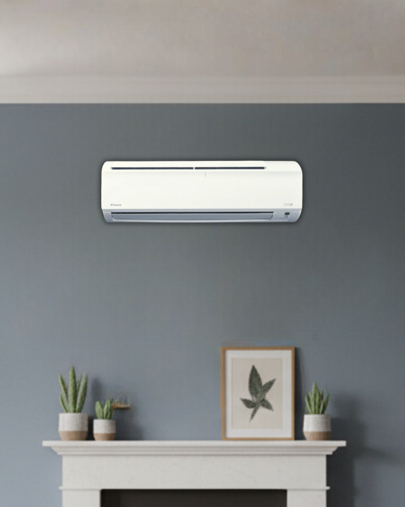 Daikin wall air conditioner on a soft grey feature wall above a white console table with potted plants and framed leaf print.