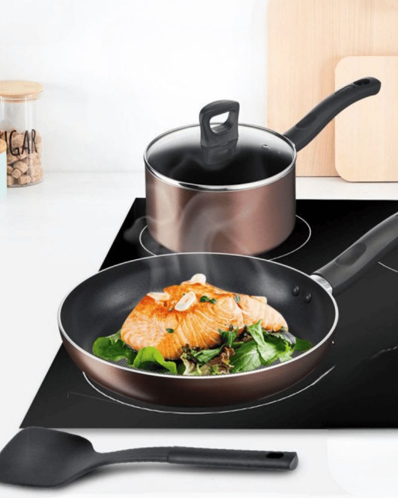 Tefal 4-piece non-stick cookware set with pan and pot on a stove.