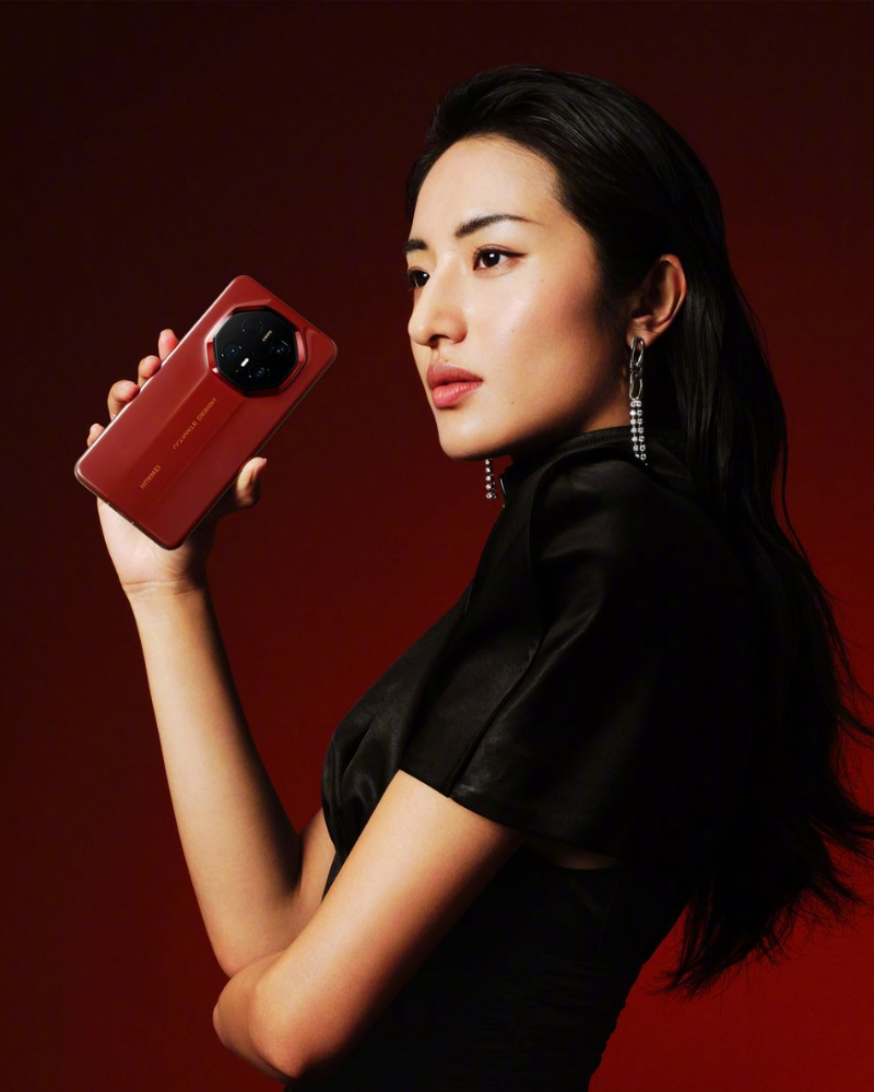 Promotional image of a woman holding a red Huawei Mate XT smartphone, highlighting the device as part of the ‘Huawei Mate XT Series’ with the tagline ‘Iconic Flagship