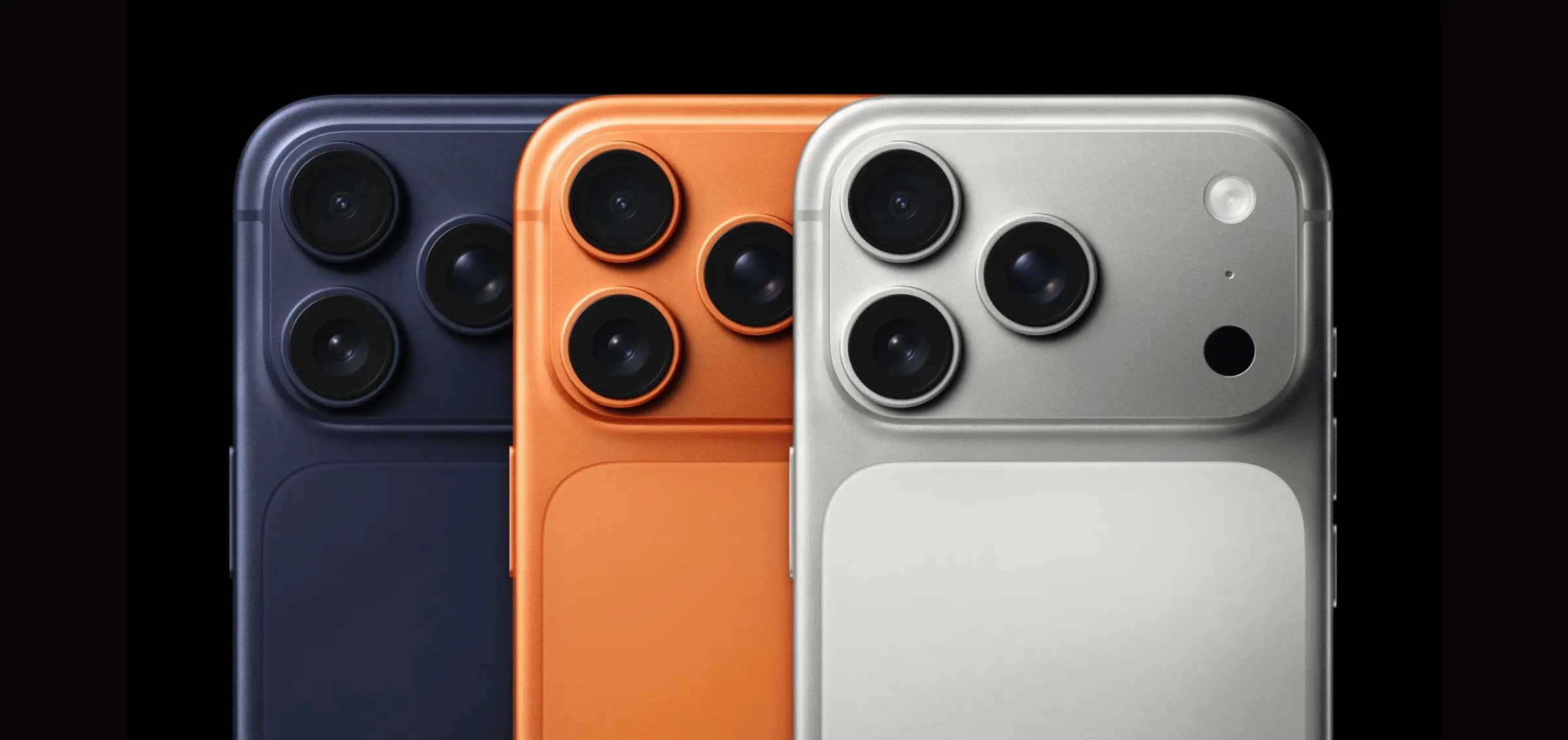 Close-up of three iPhone models in navy, orange, and silver, showing triple-camera design.
