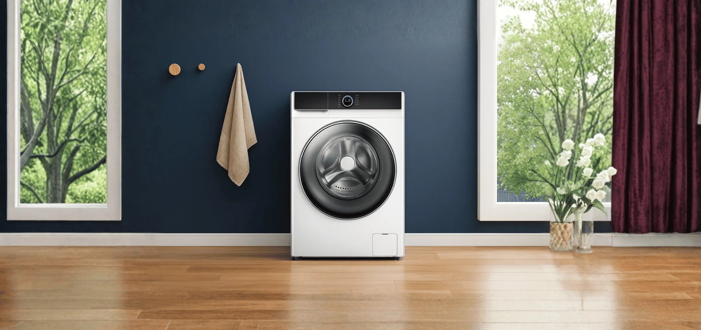 Front-load washing machine in modern laundry room with wooden floor, large windows, and decorative plants, showcasing the laundry appliances category.