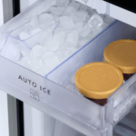 A flexible divided ice box inside the freezer, showing ice cubes stored on one side and two lidded containers on the other, demonstrating adjustable frozen storage space.